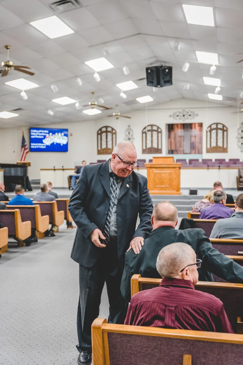 A warm greeting among people in Beth Haven’s church auditorium